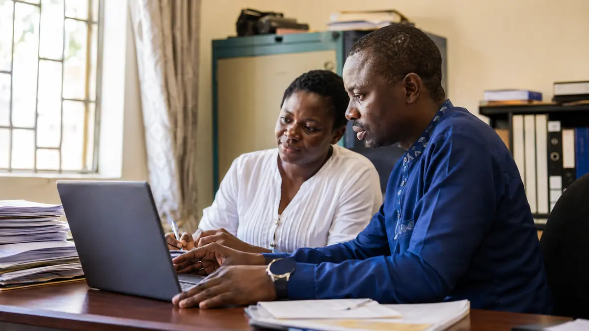 Public-health professionals using a laptop to connect programme information with practical decisions